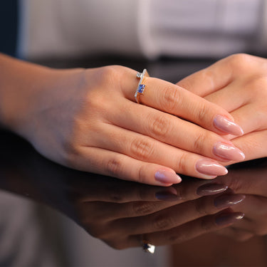 GEOMUSE RING with tanzanite and diamonds set in 18k gold on a hand, showcasing elegance and sophistication.