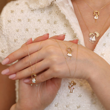 Gold character jewelry featuring a girl in a white dress with a diamond flower, crafted in 18k gold.
