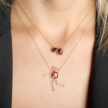 Handmade 18k gold necklace with vibrant ruby character piece, perfect for symbolizing mother and child bond, titled "MIRA".