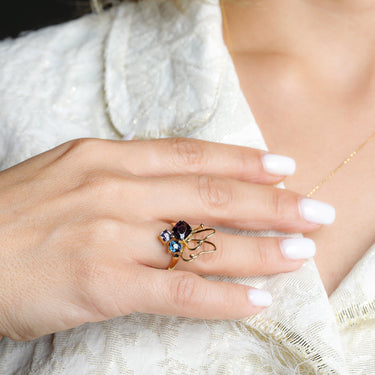 Butterfly ring with 3 purple spinel stones in 18k gold on finger, Luminus Wings Ring.