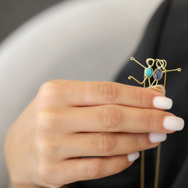 Handmade 18k gold necklace featuring AMIN & ADRIANA characters with blue sapphire and feroza stones.