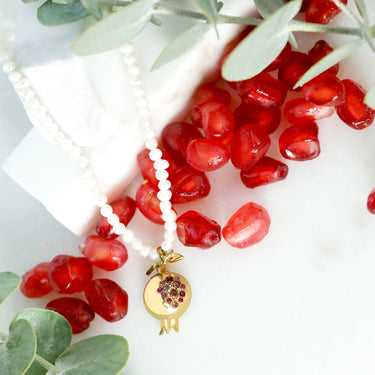 Pomegranate pendant on pearl necklace with pink sapphire in 18K gold.