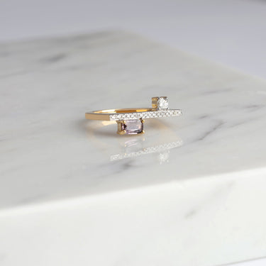 18K gold GEOMUSE ring with baguette tourmaline and diamonds on marble surface.