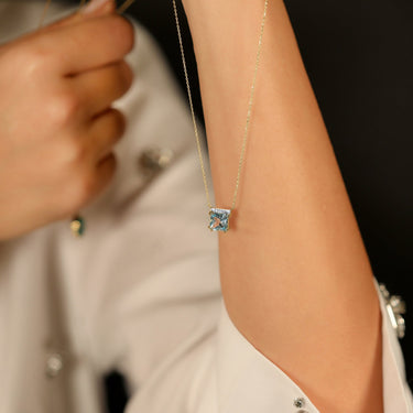 Geometric 18k gold necklace with aquamarine and diamond accents.
