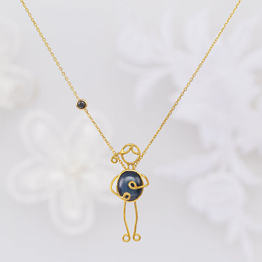 Handmade 18k gold necklace with a blue sapphire and black diamond, symbolizing love and strength.