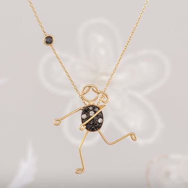 Handmade 18k gold character necklace with black and white diamond accents, symbolizing unity.