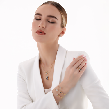 DESERT ROSE RING in gold with tanzanite and diamonds worn by a model in white attire.